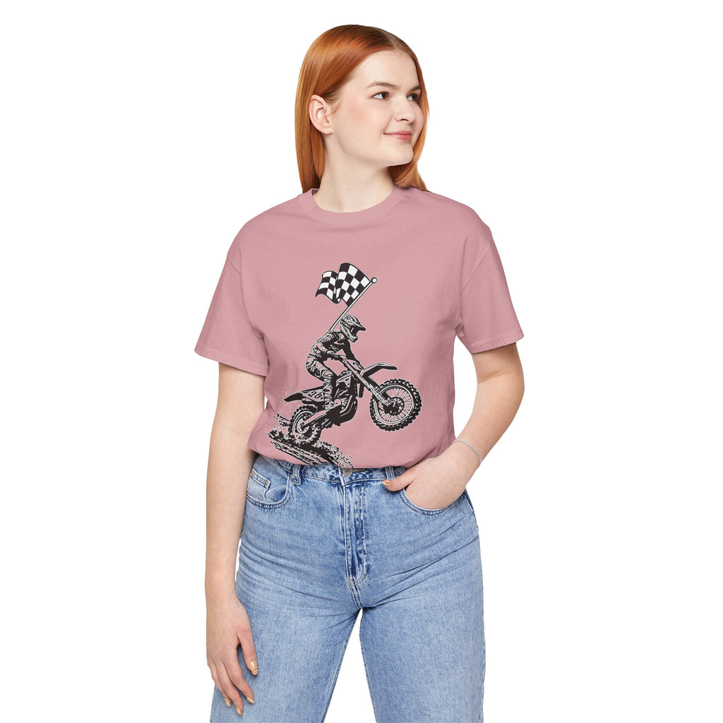 Person wearing a pink t-shirt with a graphic design of a motorcycle and checkered flag, standing against a white background.