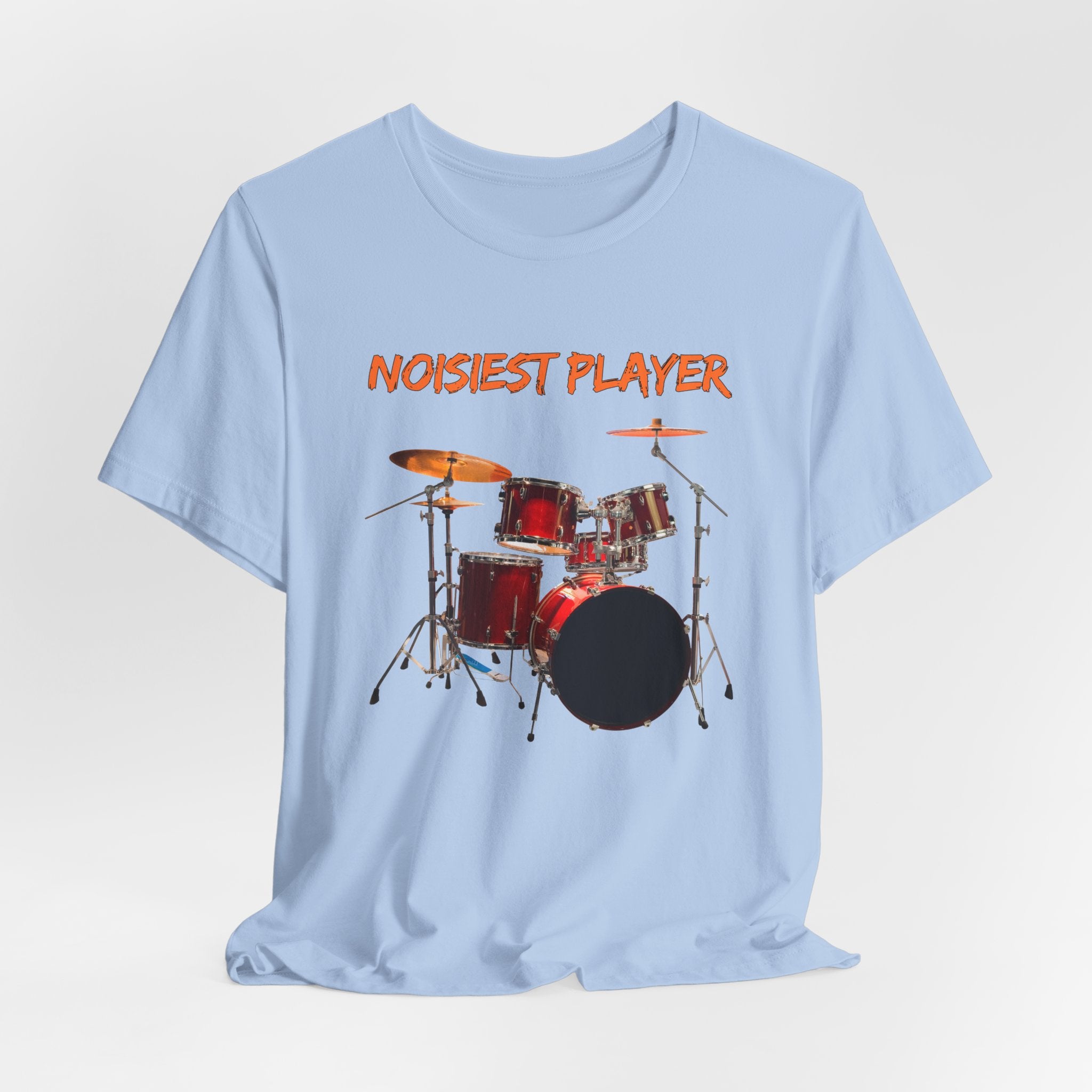 Light blue t-shirt with drum set graphic and 'NOISIEST PLAYER' text on a light gray background