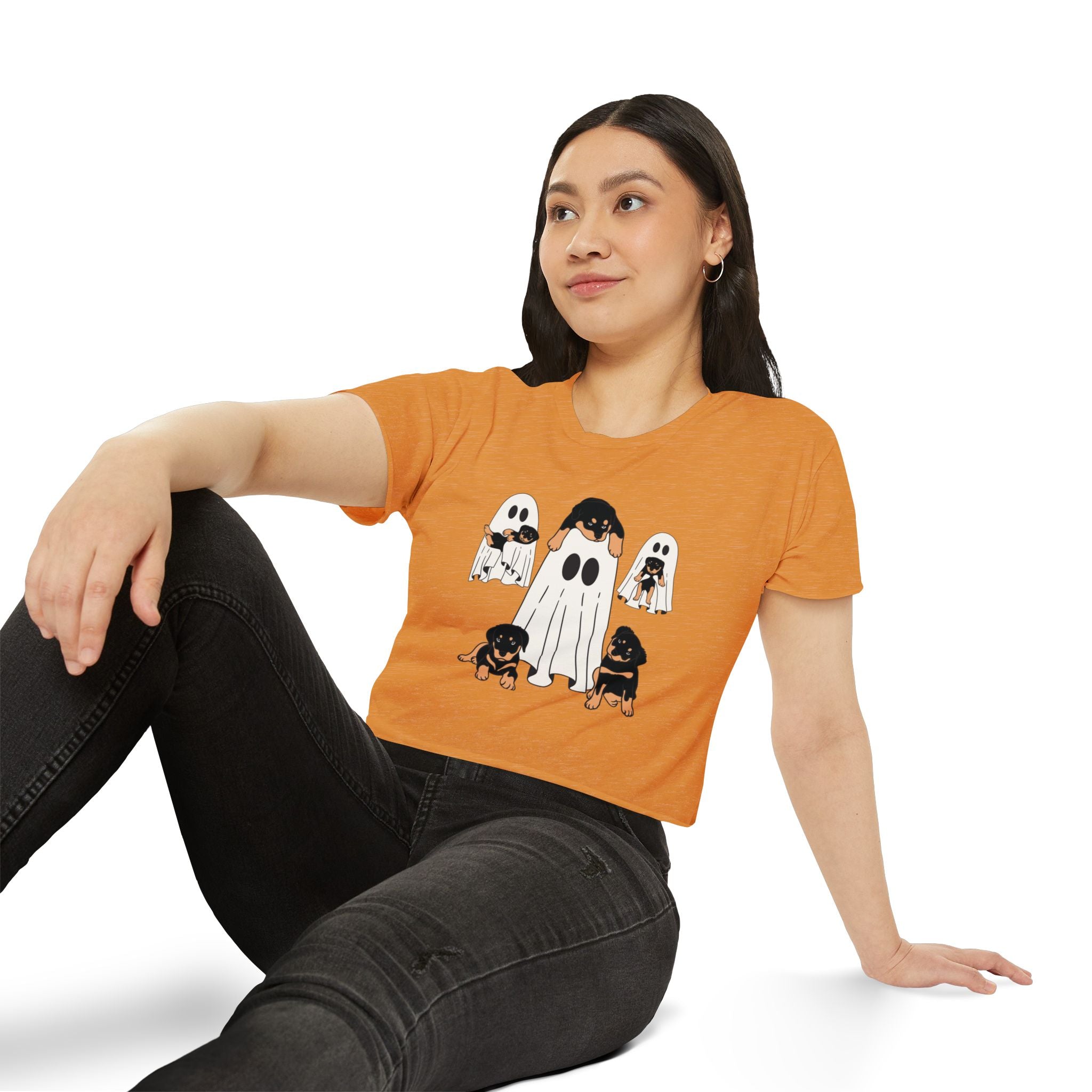 Woman wearing an orange t-shirt with ghost and dog illustrations on a white background