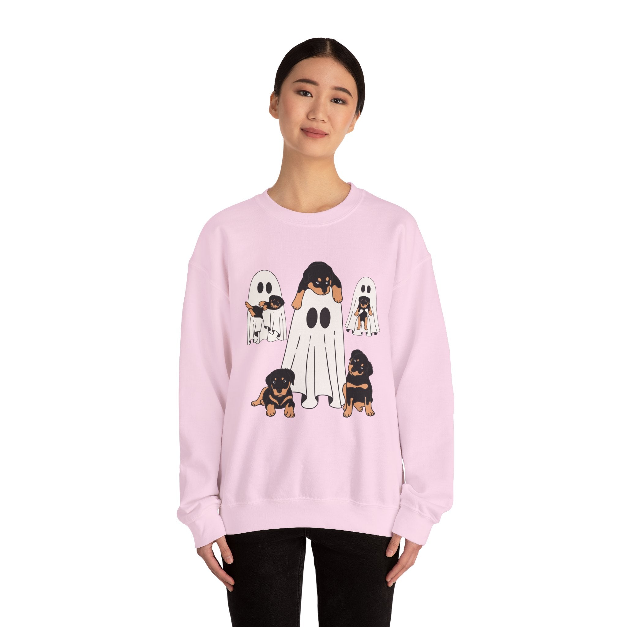 Person wearing a pink sweatshirt with ghost-themed dog illustrations on a white background