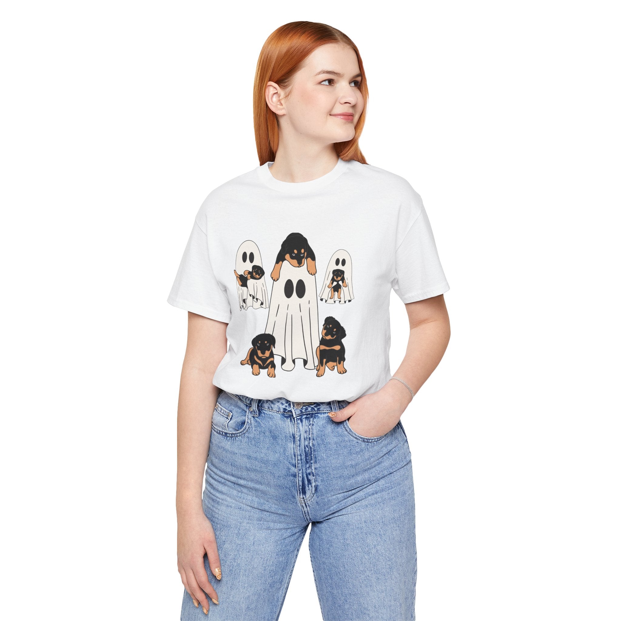 Person wearing a white t-shirt with ghost and dog graphic design on a plain background