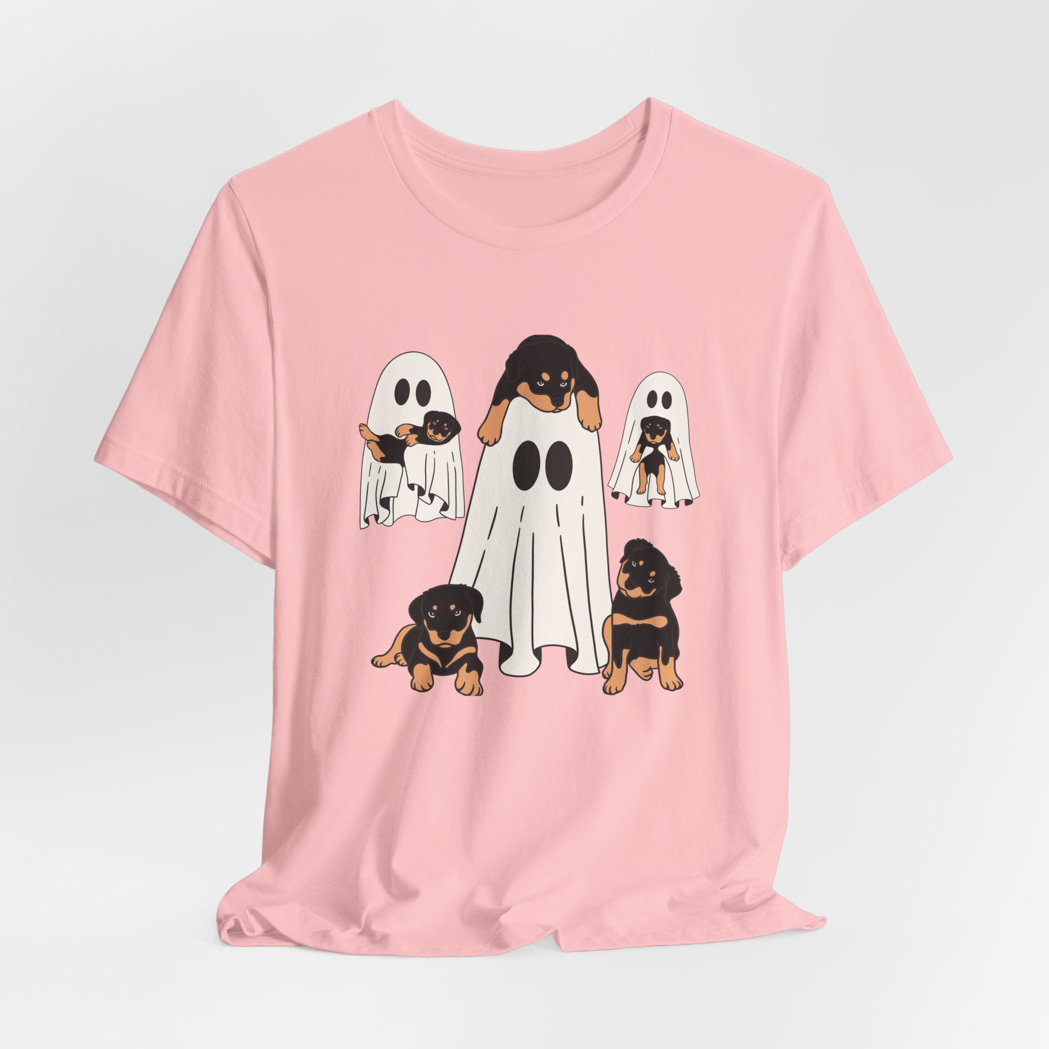Pink t-shirt with cartoon ghosts and dogs design on a light gray background