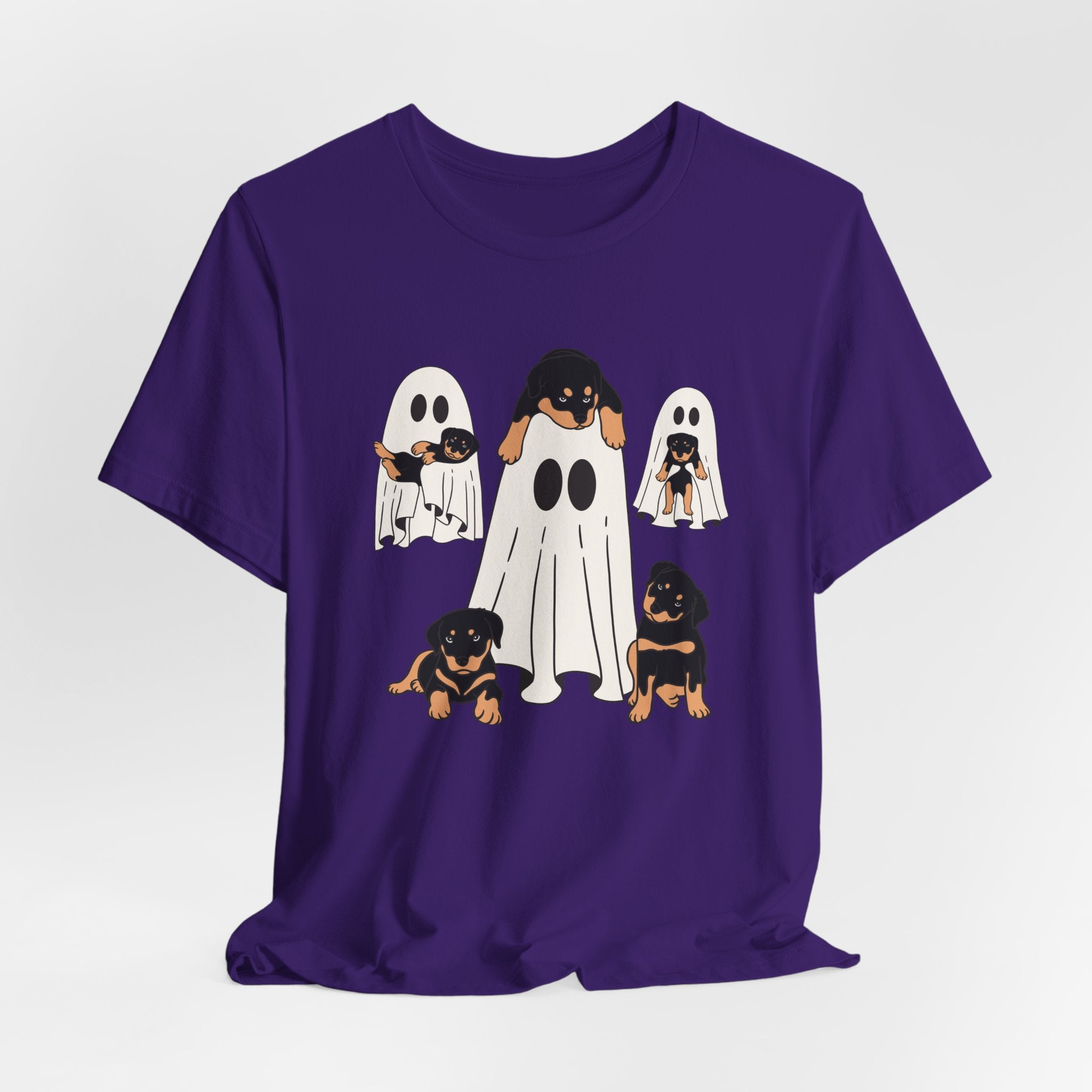 Purple t-shirt with Halloween-themed design of dogs in ghost costumes on a white background