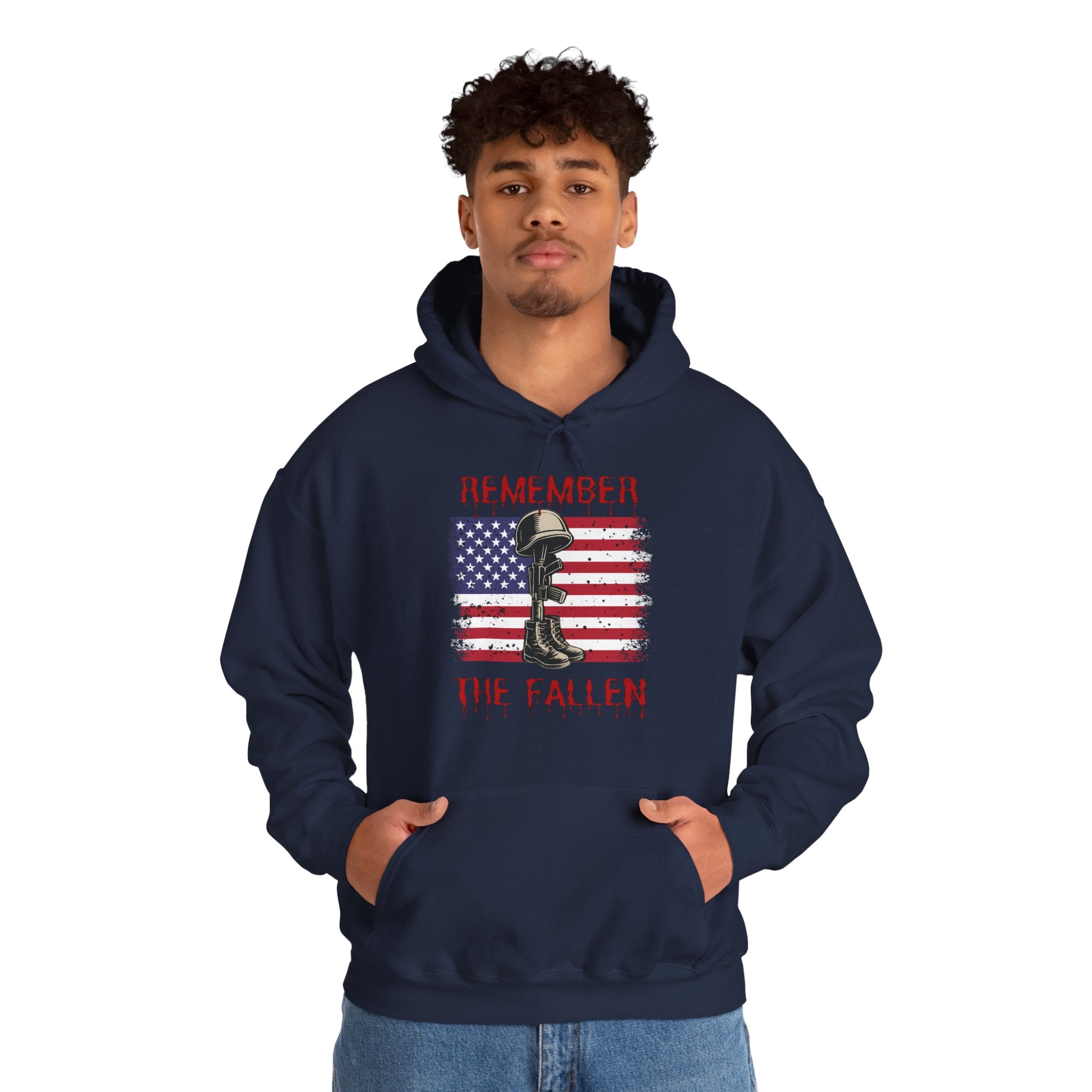 Person wearing a navy blue hoodie with a graphic design of vintage American flag with soldiers gear and "Remember the Fallen" text on a white background