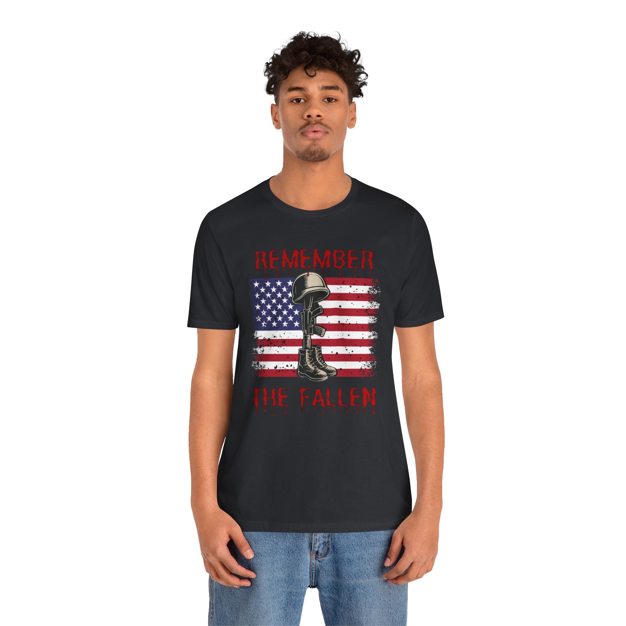 Person wearing a black t-shirt with vintage American flag and military gear themed design with remember the fallen text on a white background