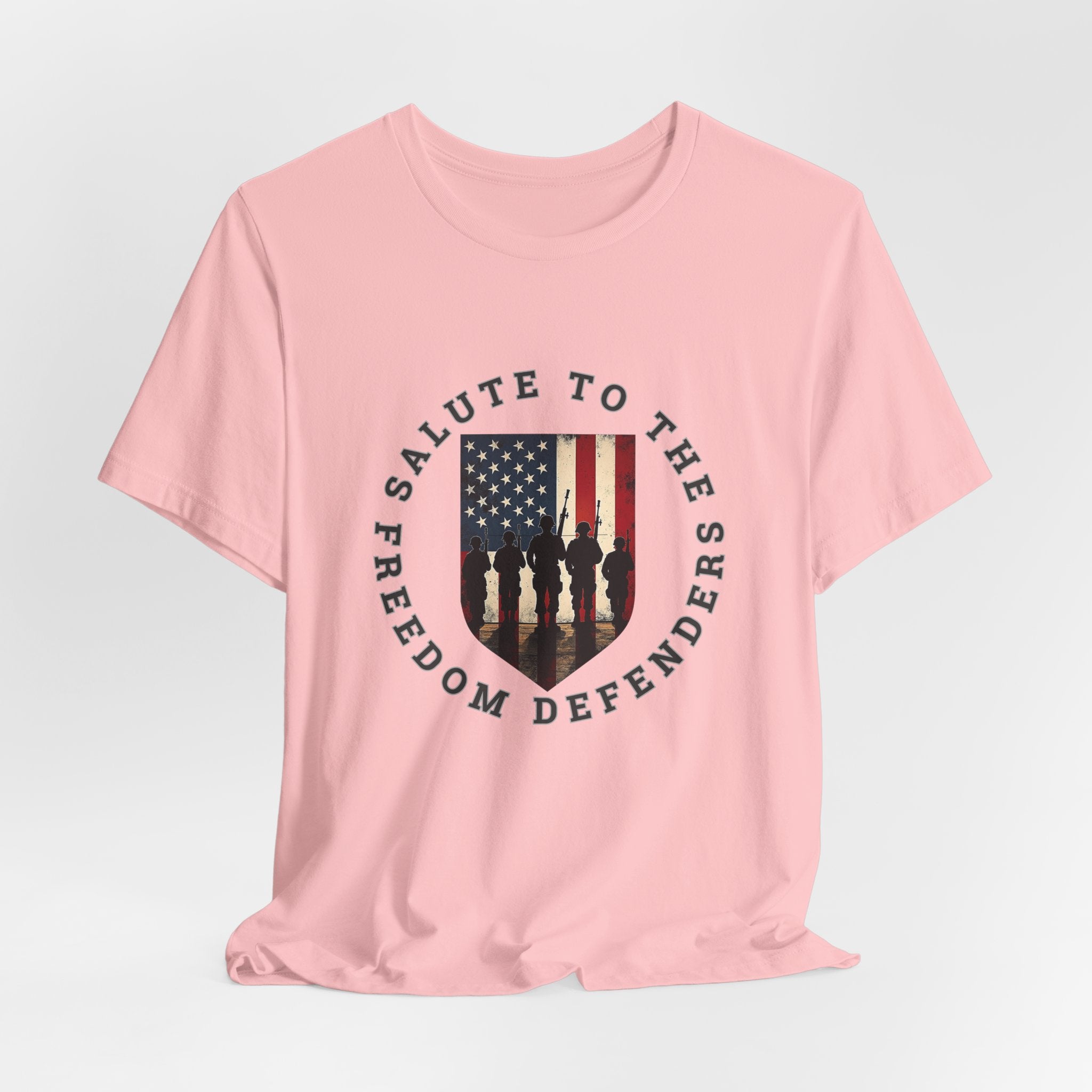 Pink t-shirt with 'Salute to the Freedom Defenders' design featuring an American flag and silhouette of soldiers on a white background.