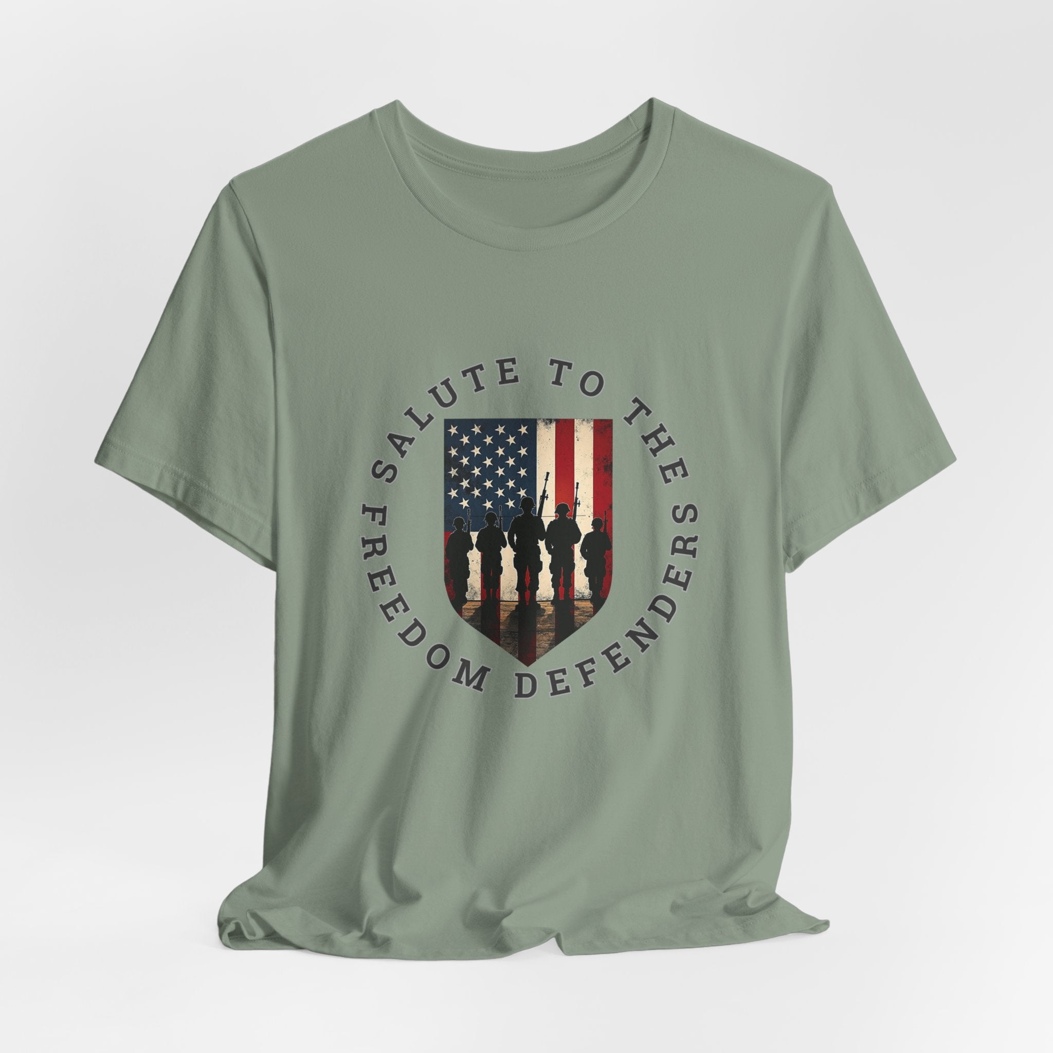 Sage green t-shirt with 'Salute to the Freedom Defenders' design featuring an American flag and silhouette of soldiers on a white background.