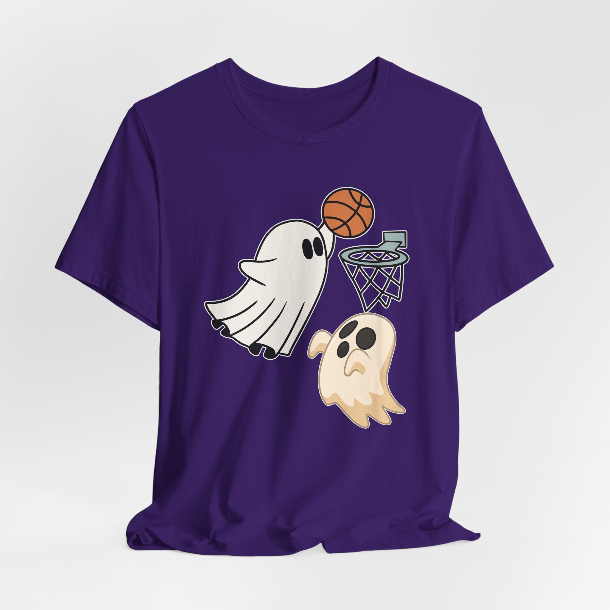 Team purple t-shirt featuring cute spooky halloween ghosts playing basketball design on a white background