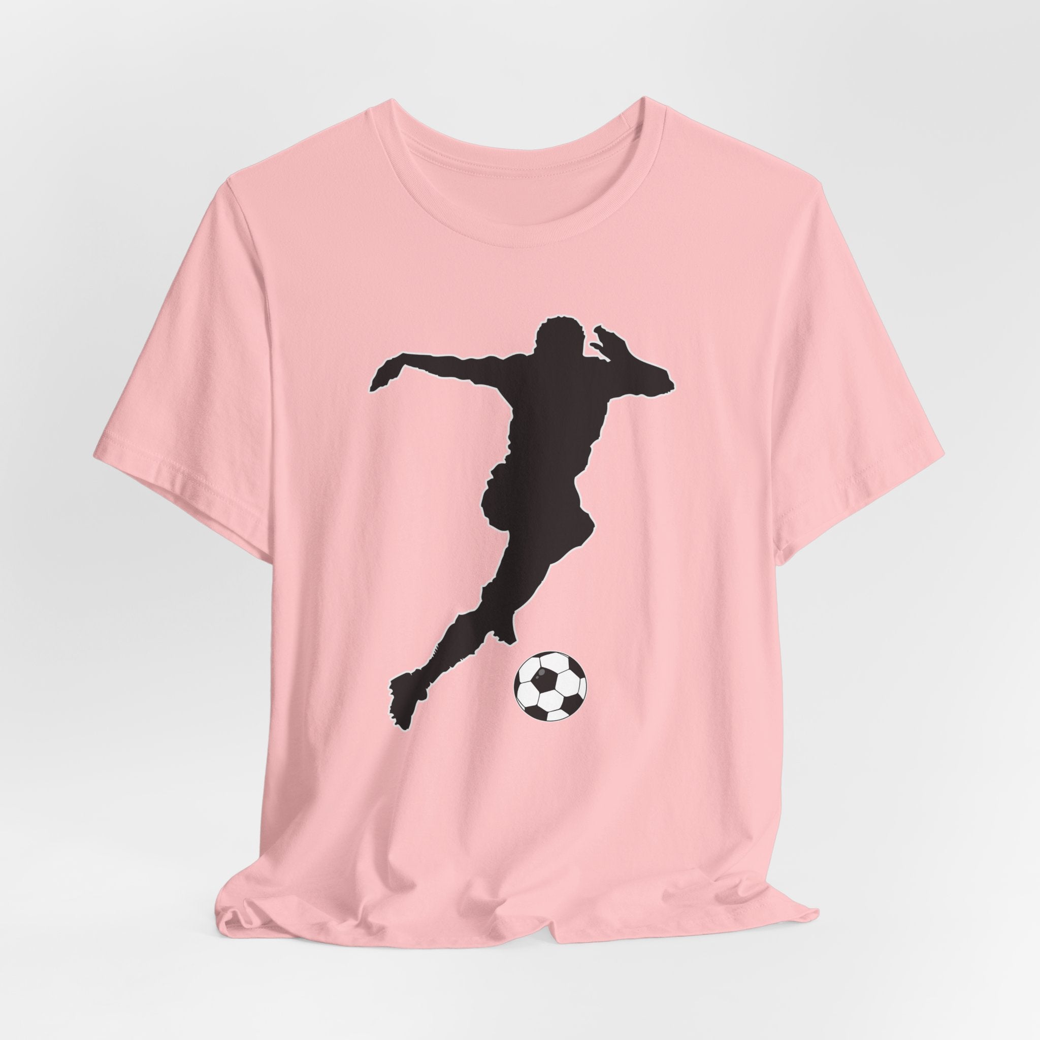 Pink t-shirt with a black silhouette of a soccer player and ball on a light gray background