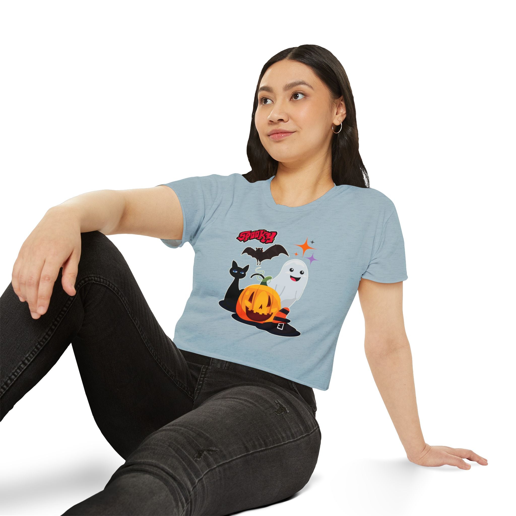 Woman wearing a light blue t-shirt with Halloween-themed graphics on a white background