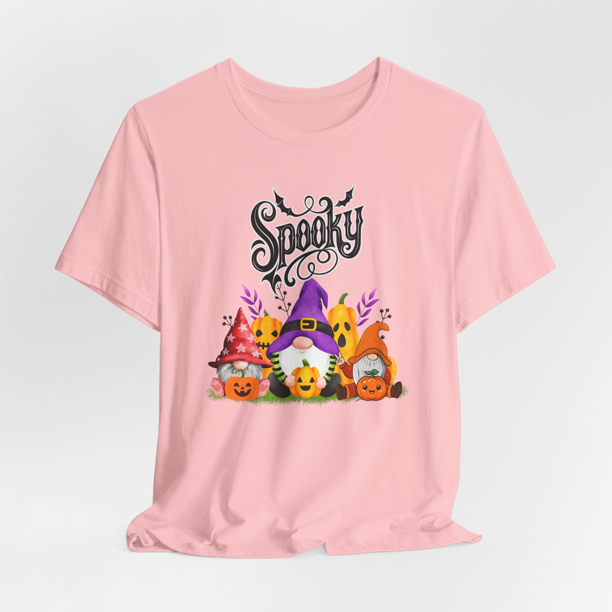 Pink t-shirt with Halloween-themed design featuring spooky gnomes and pumpkins on a white background