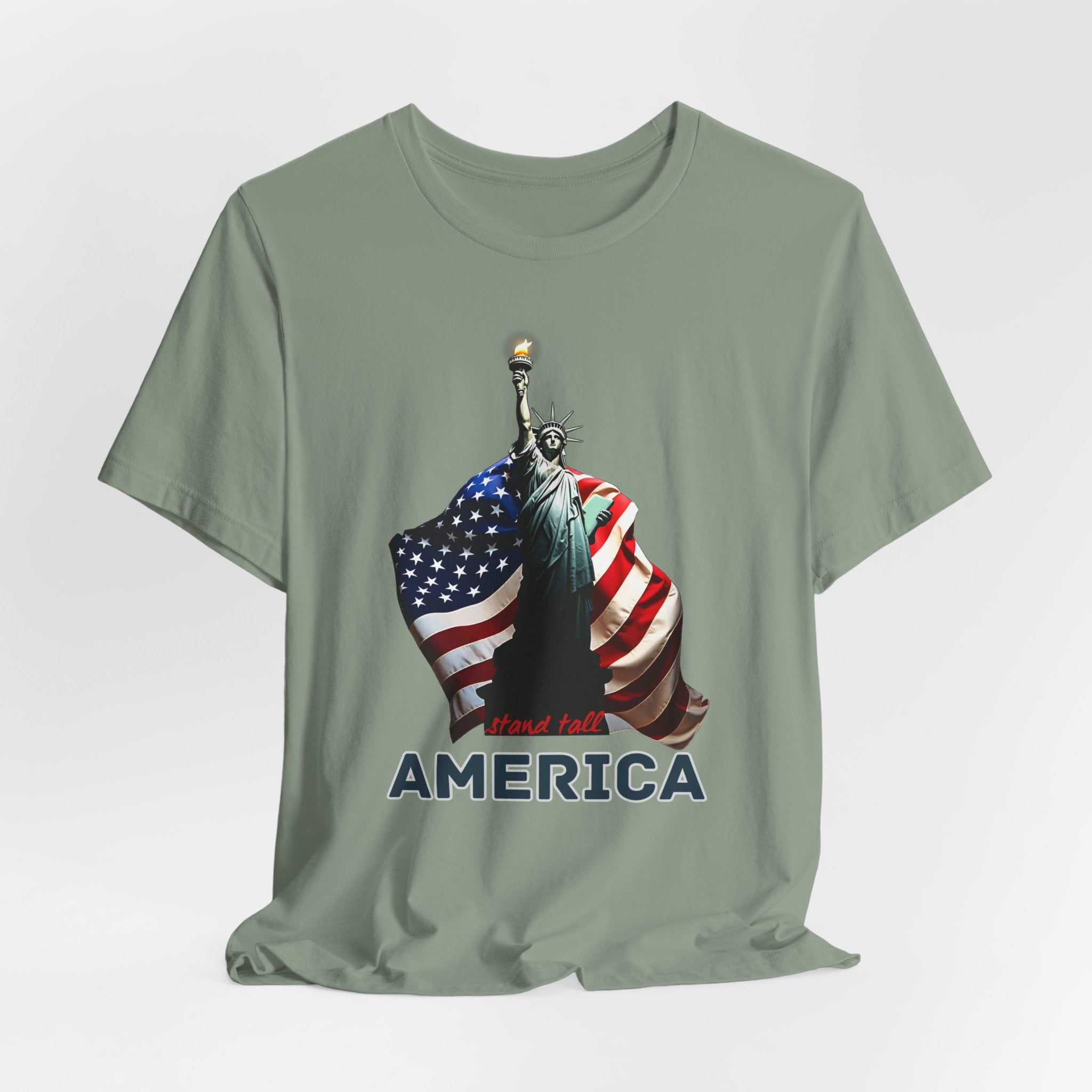 Sage green t-shirt with Statue of Liberty and American flag design with stand stall America on a white background