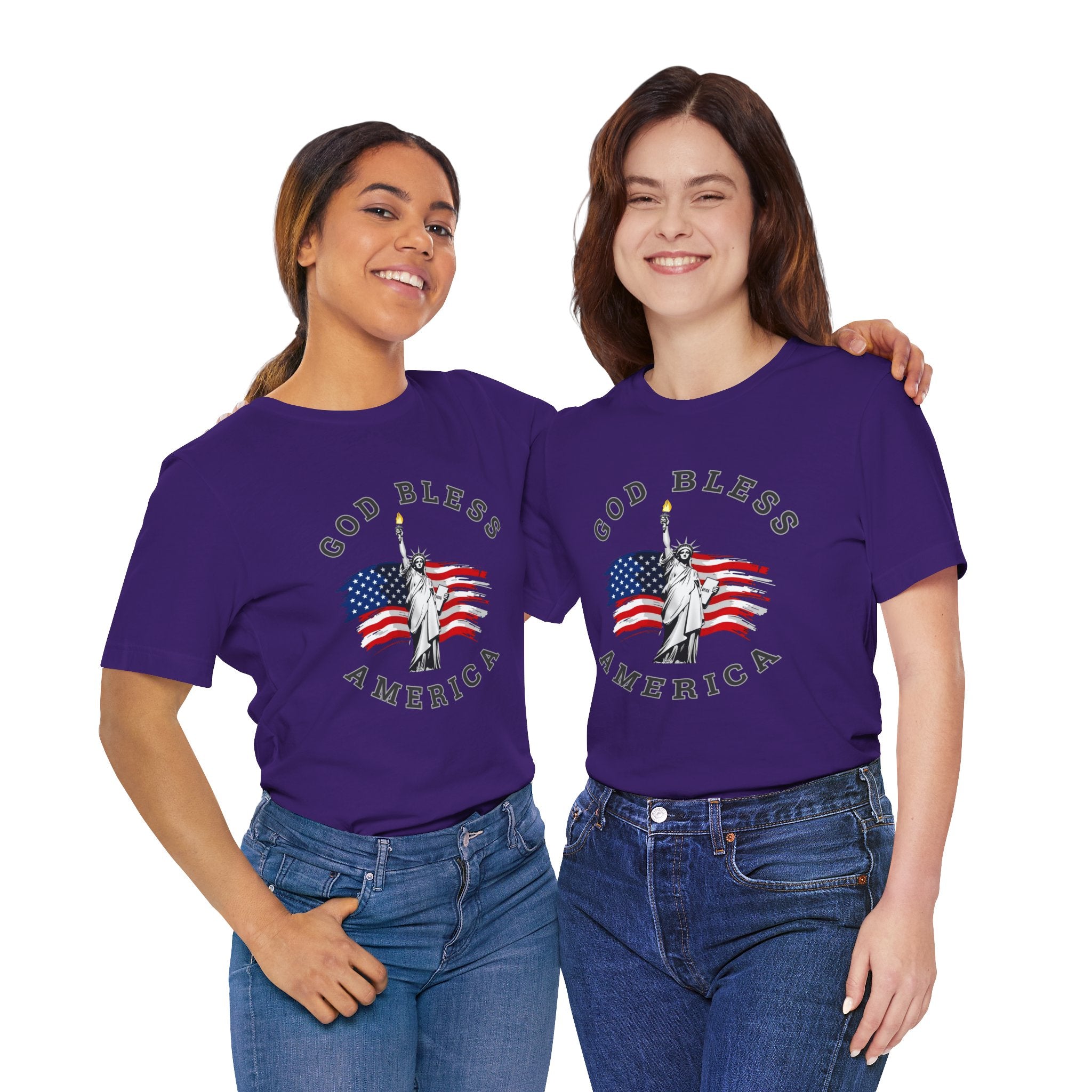 Two women wearing purple t-shirts with 'God Bless America' and Statue of Liberty design on a white background.