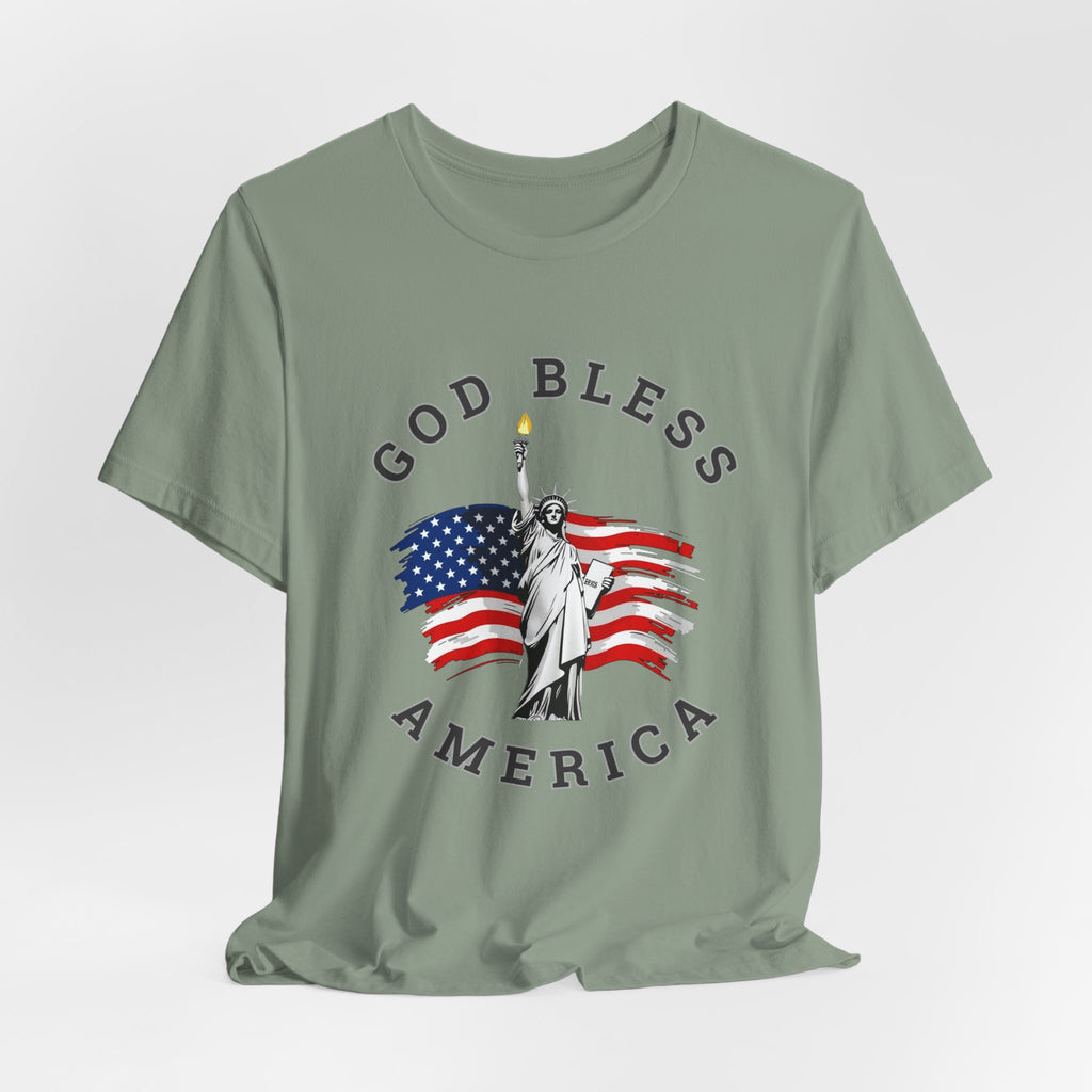 Sage t-shirt with 'God Bless America' graphic featuring the Statue of Liberty and American flag on a light gray background.