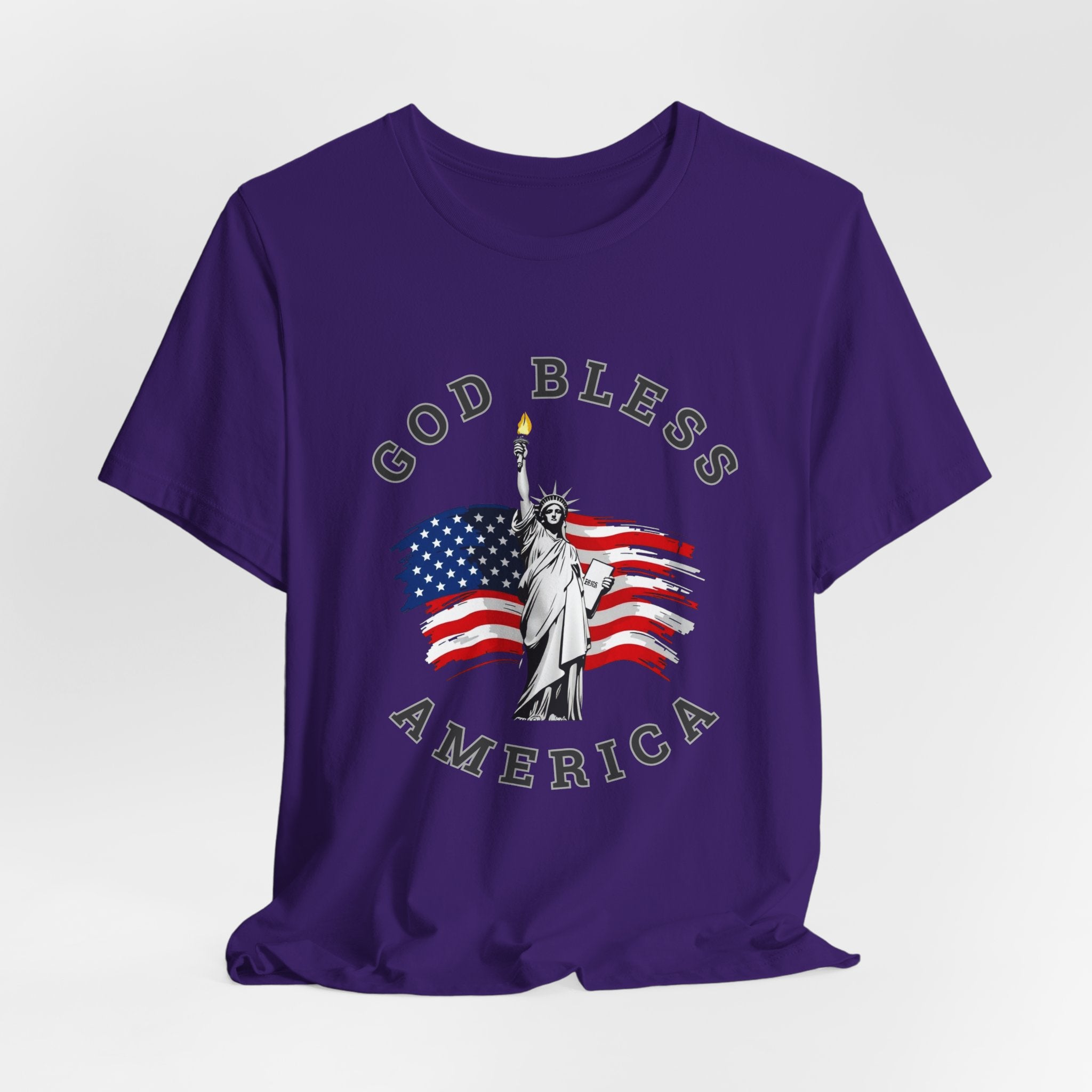 Purple t-shirt with 'God Bless America' graphic featuring the Statue of Liberty and American flag on a white background