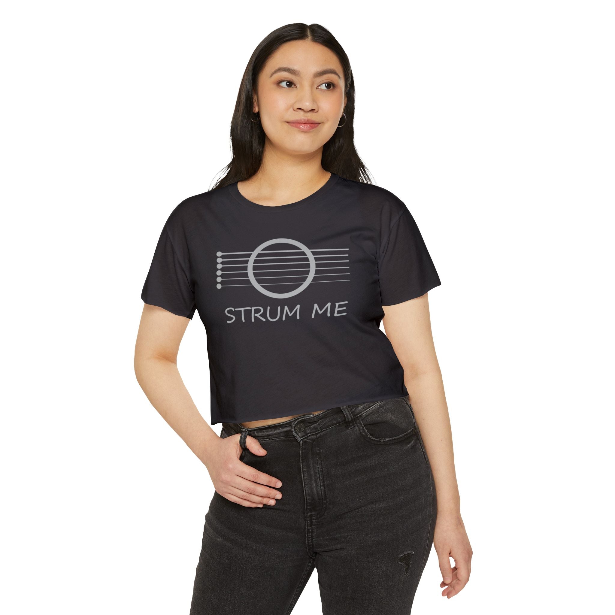 Woman wearing a black t-shirt with 'STRUM ME' text and graphic on a white background