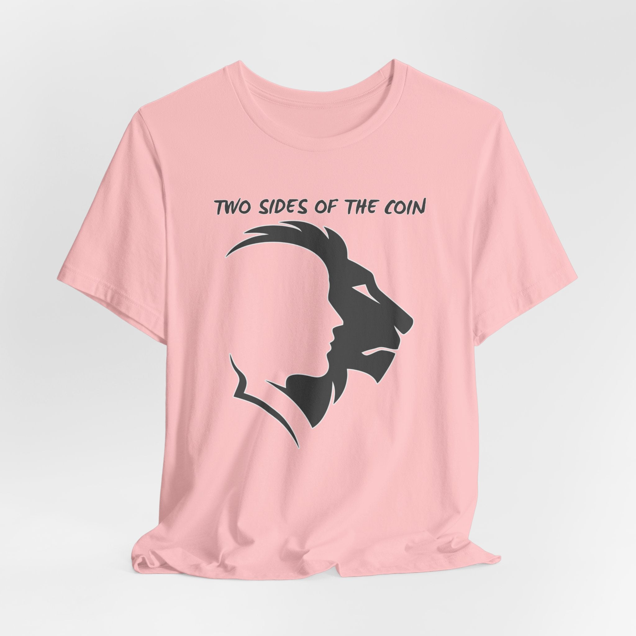 Pink t-shirt with dark gray graphic of lion and human faces and text 'Two Sides of the Coin' on a light gray background