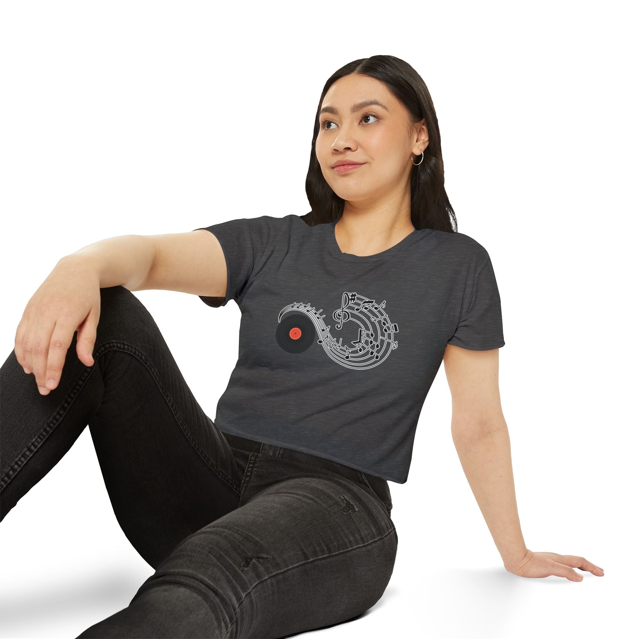 Woman wearing a dark gray t-shirt with a graphic design, sitting on a white background