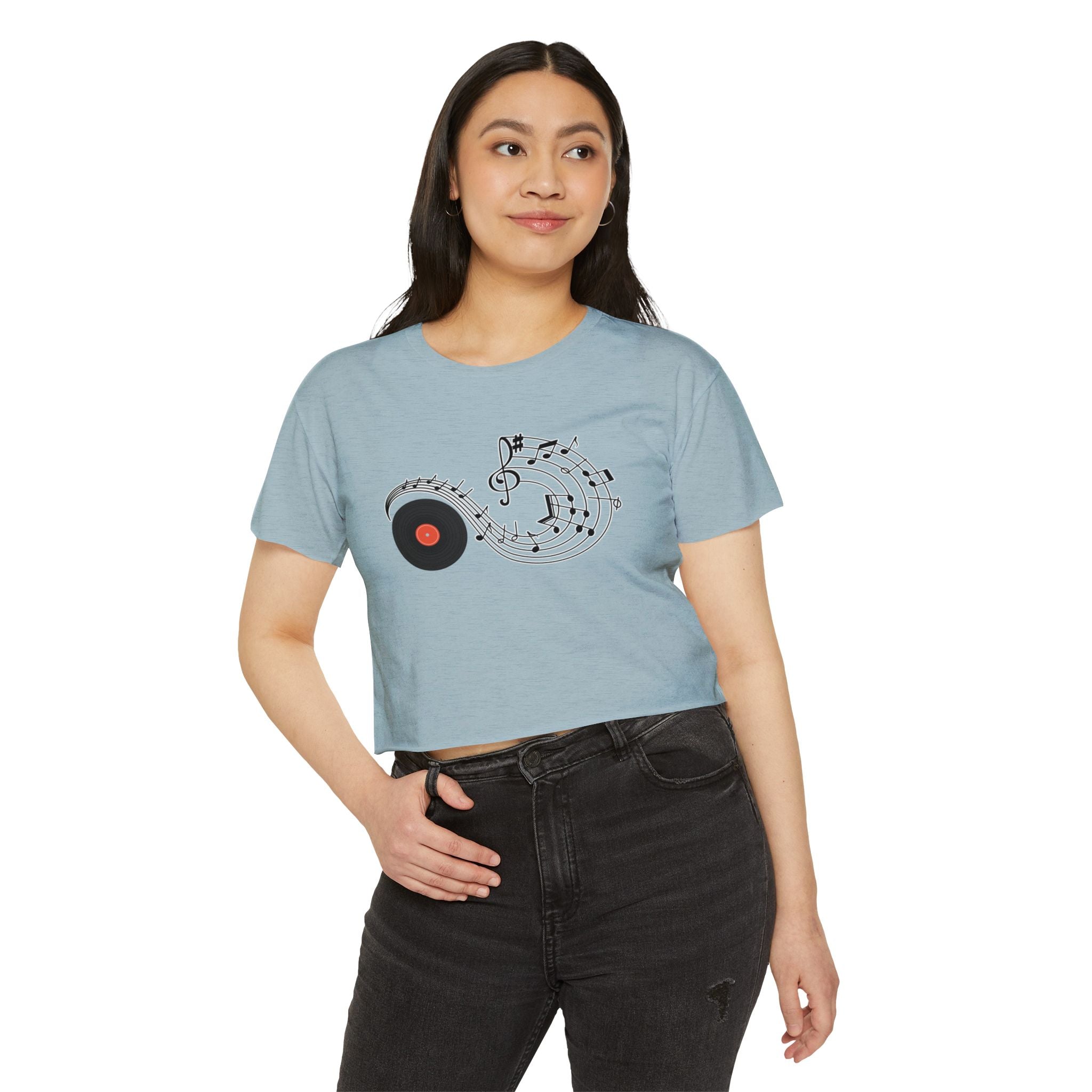 Woman wearing a light blue t-shirt with a music-themed design on a white background