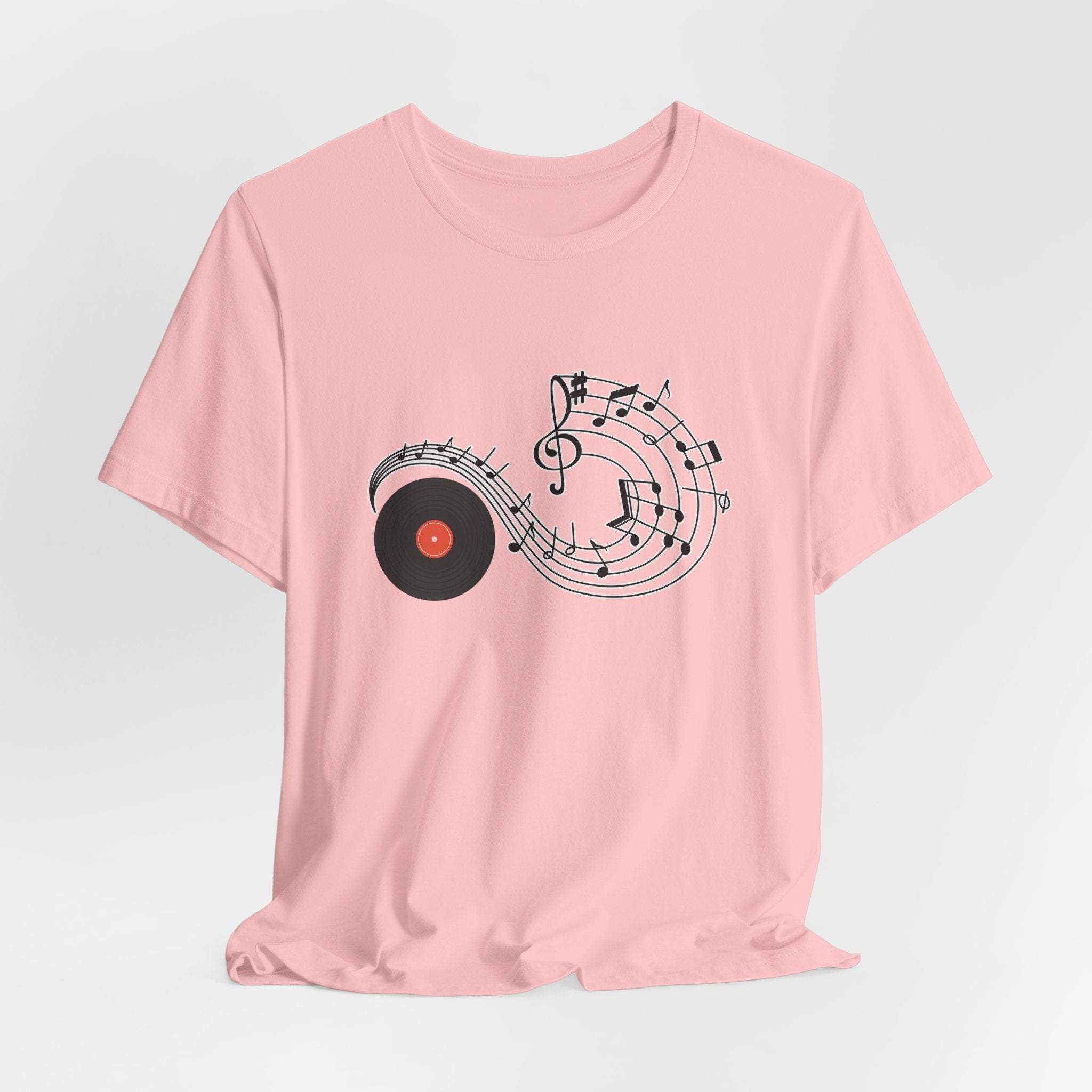 Pink t-shirt with music-themed design on a light gray background