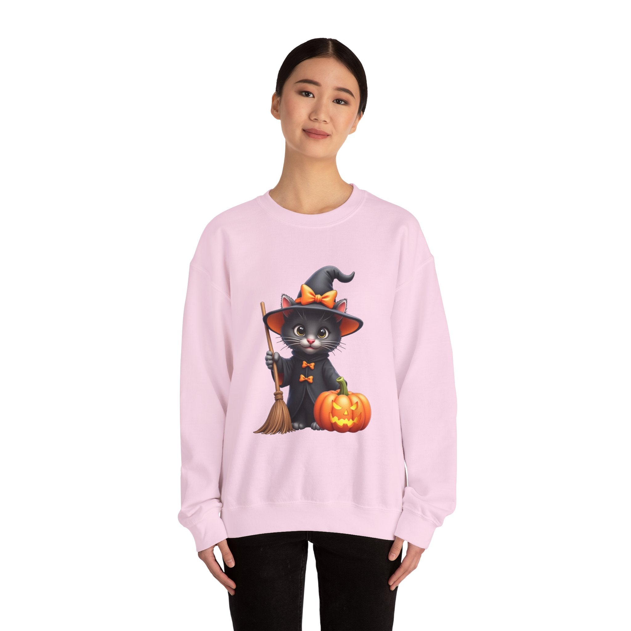 Person wearing a pink sweatshirt with a Halloween design of a cat on a broomstick.