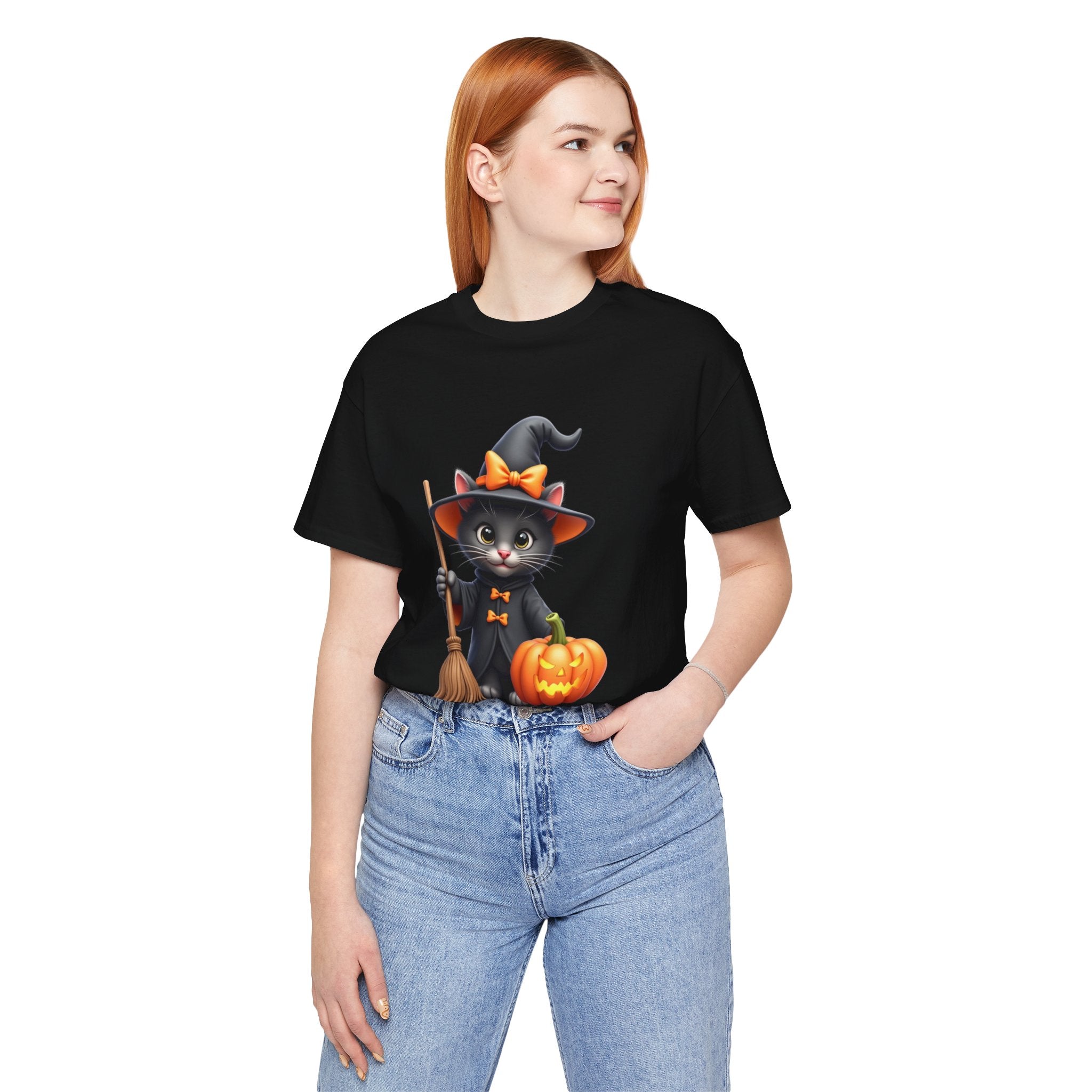 Person wearing a black t-shirt with a Halloween-themed design of a cat, witch hat, and pumpkin.