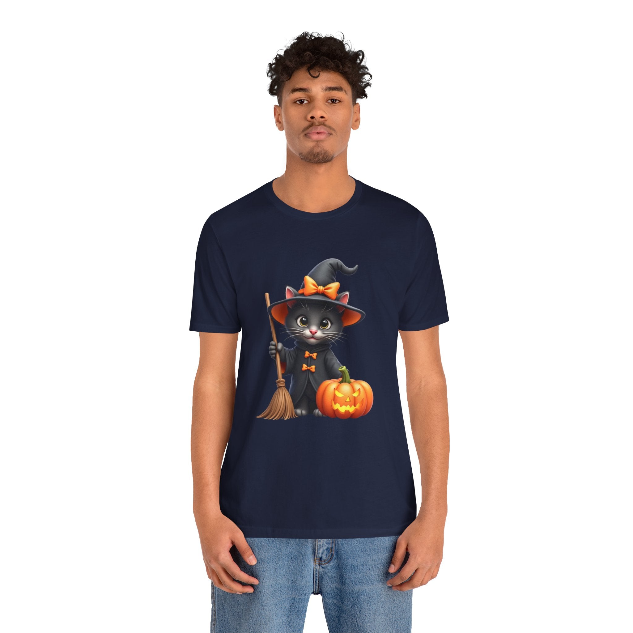 Person wearing a navy blue t-shirt with a Halloween-themed design featuring a cat, broom, and pumpkin.