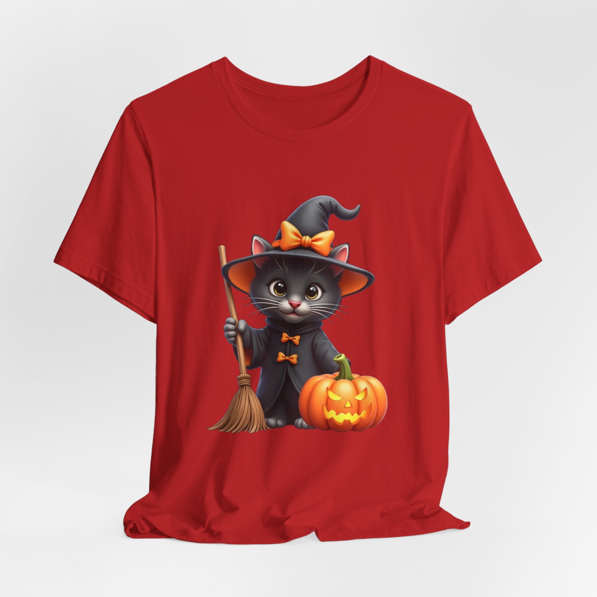 Red t-shirt with a Halloween-themed design of a cat in a witch costume, broom, and pumpkin on a white background.