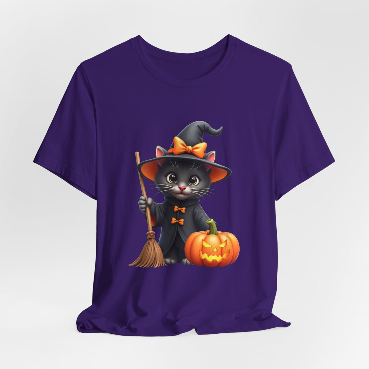 Purple t-shirt with a Halloween-themed design of a cat in a witch costume, broom, and pumpkin on a white background.