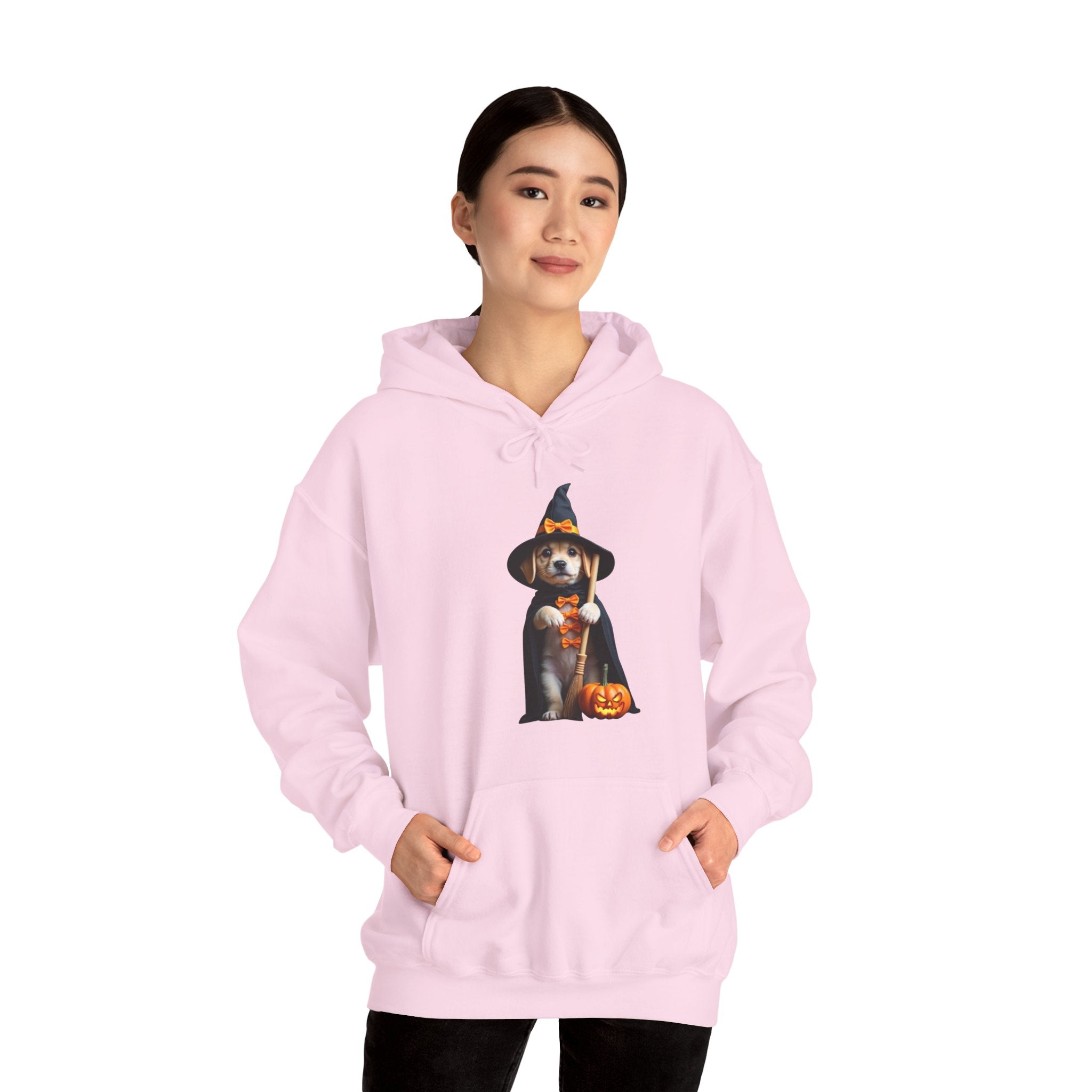 Person wearing a pink hoodie with a dog in a witch hat design on a white background