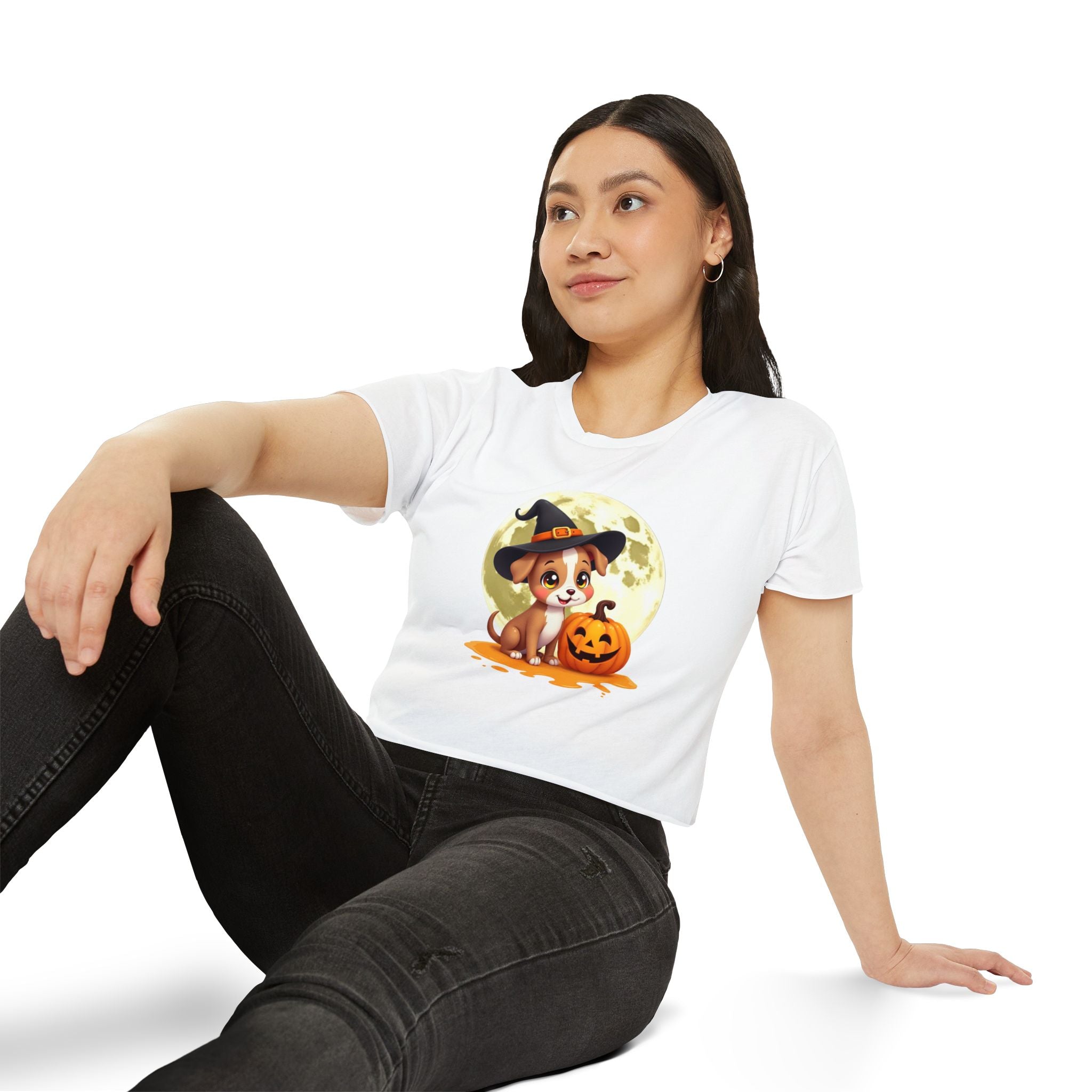 Woman wearing a white t-shirt with a Halloween-themed graphic of a dog in a witch hat and pumpkin.