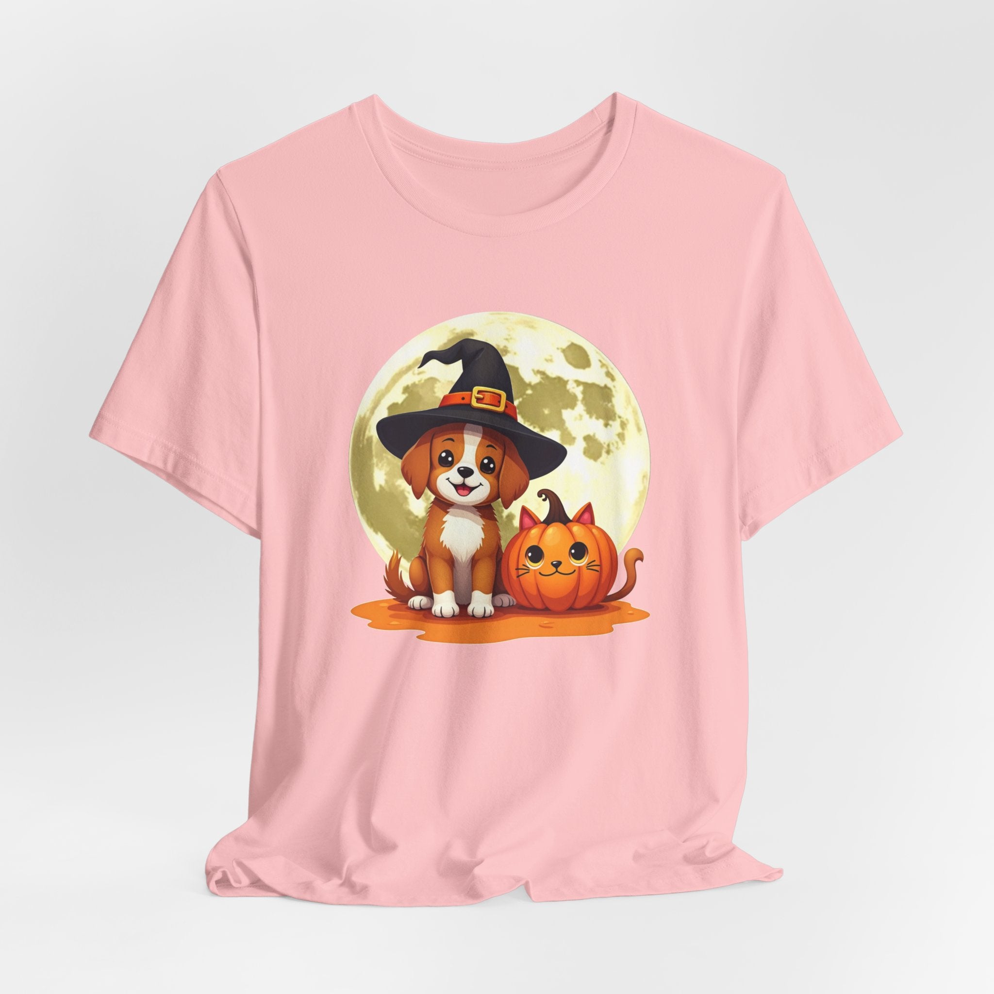 Pink t-shirt with a Halloween-themed design featuring a dog in a witch hat and pumpkin on a light gray background.