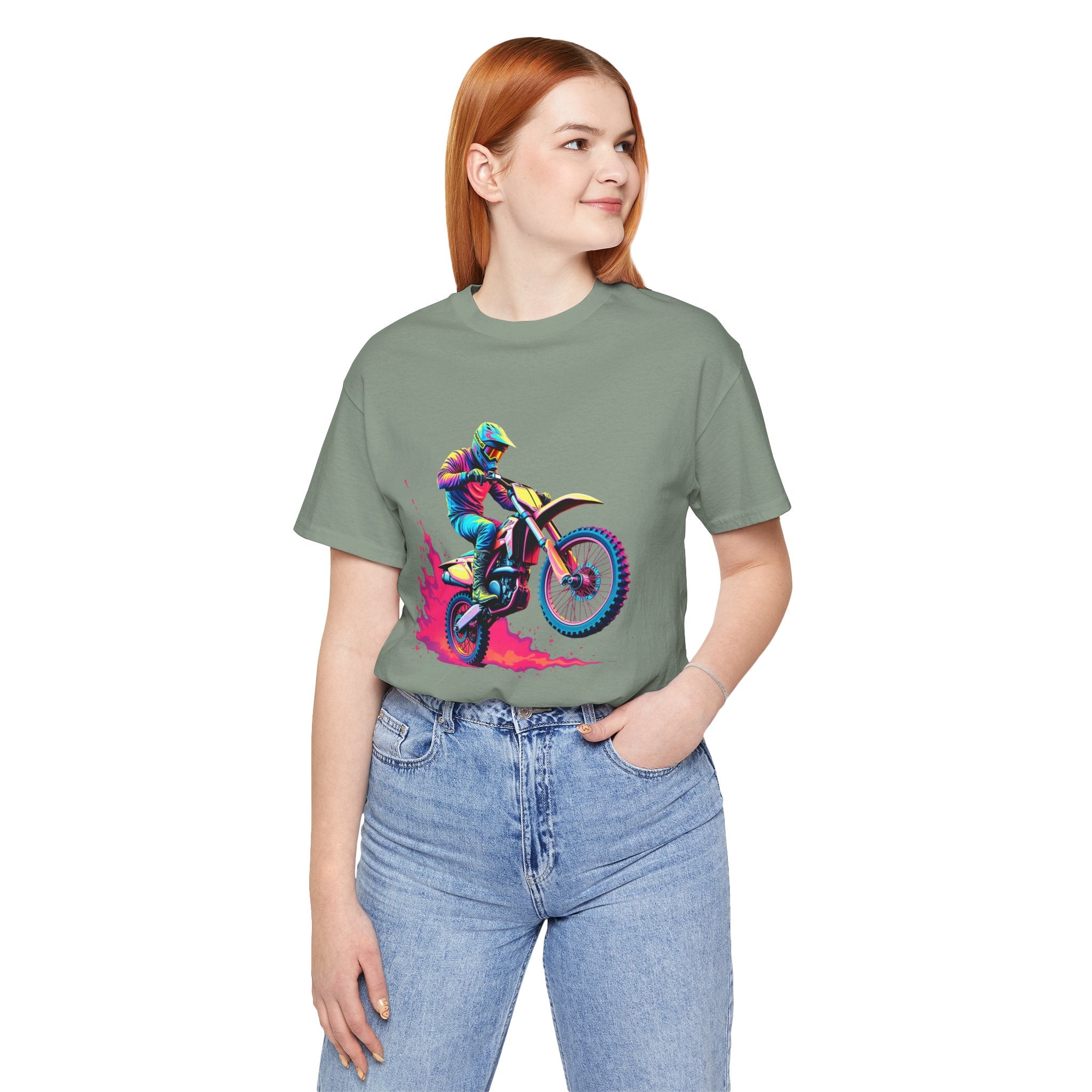 Person wearing a green t-shirt with a colorful graphic of a person on a motorcycle, standing against a white background.